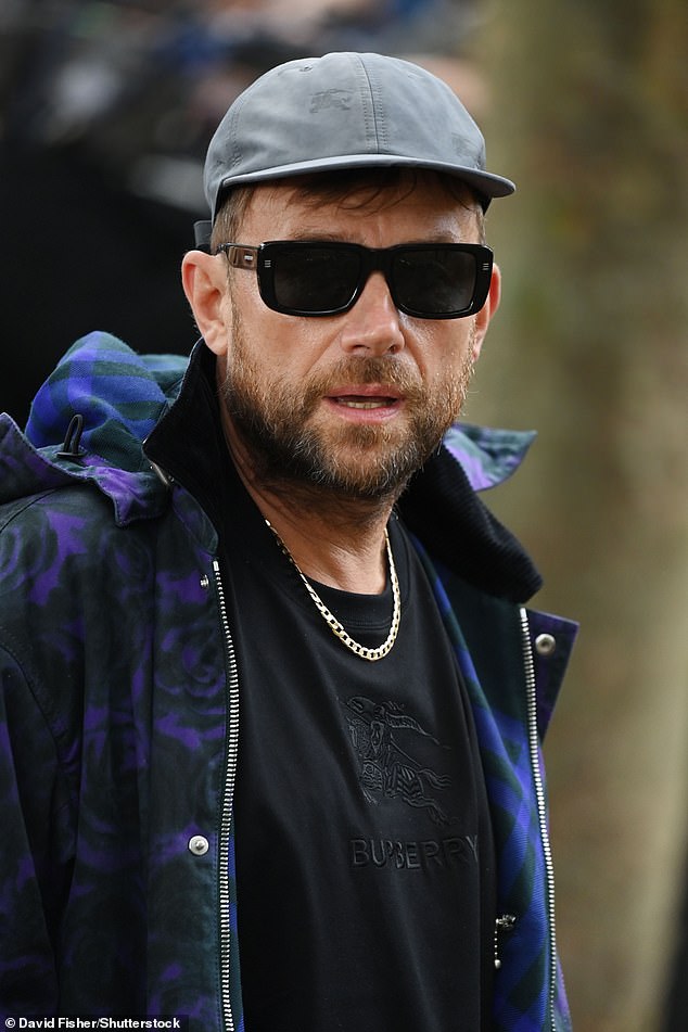 Модный форвард: участник Gorillaz завершил свой образ серой кепкой и темными солнцезащитными очками.
