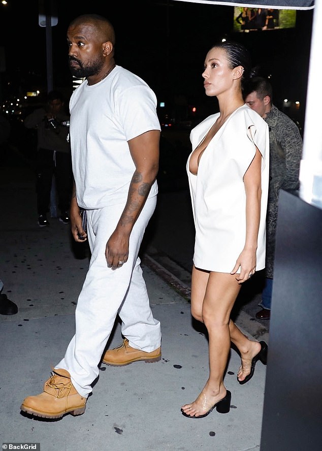 Архитектор Yeezy продемонстрировала свои богатые достоинства в типичном белом мини-платье, обнажающем кожу, до пупка.