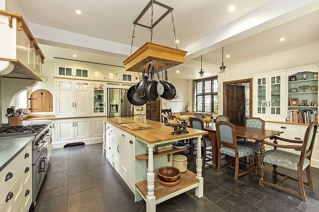 Его новый дом может похвастаться просторной кухней с большим островом посередине, а также встроенными белыми шкафами для дополнительного хранения вещей на трех стенах комнаты.